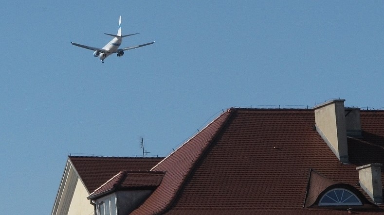 samolot nad dachami w powietrzu - Tom Foto