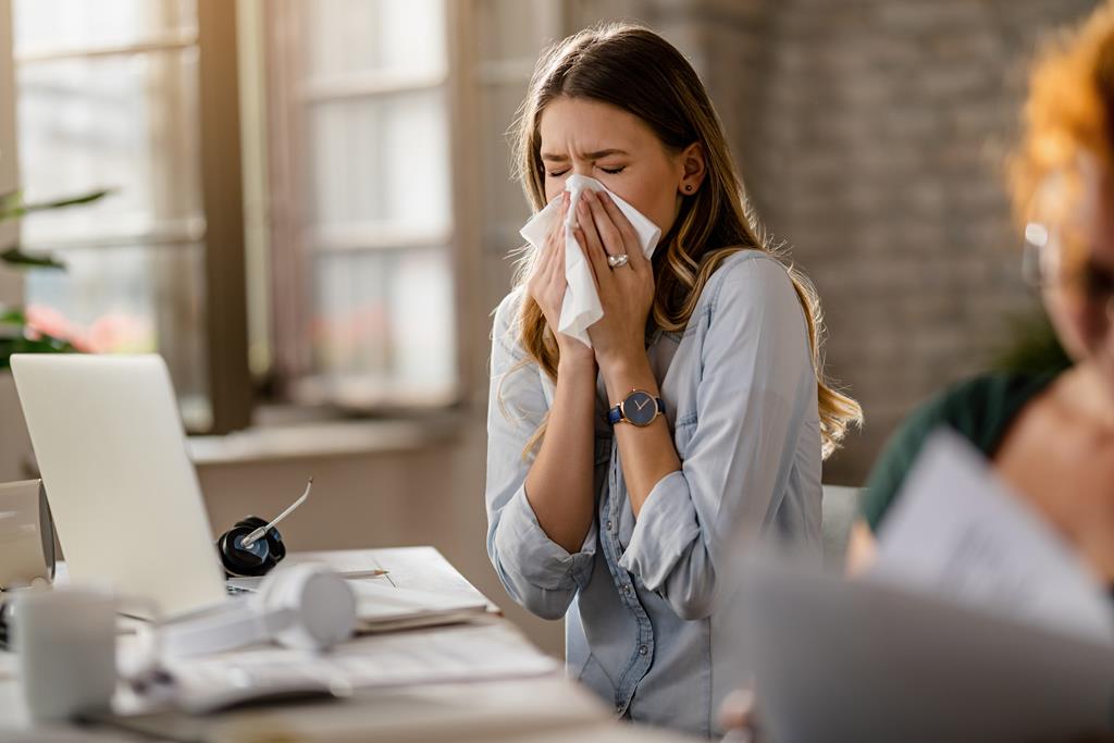 young-sick-businesswoman-sneezing-tissue-while-working-office (1) (1) (1) (Copy) - Materiał sponsorowany