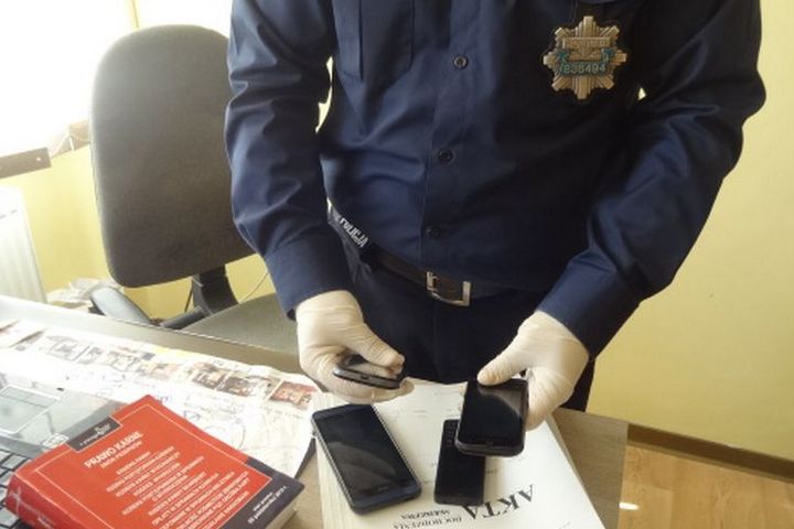 policjant z telefonami komórkowymi - KWP w Poznaniu